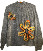 Grå striktrøje med stor blomst.